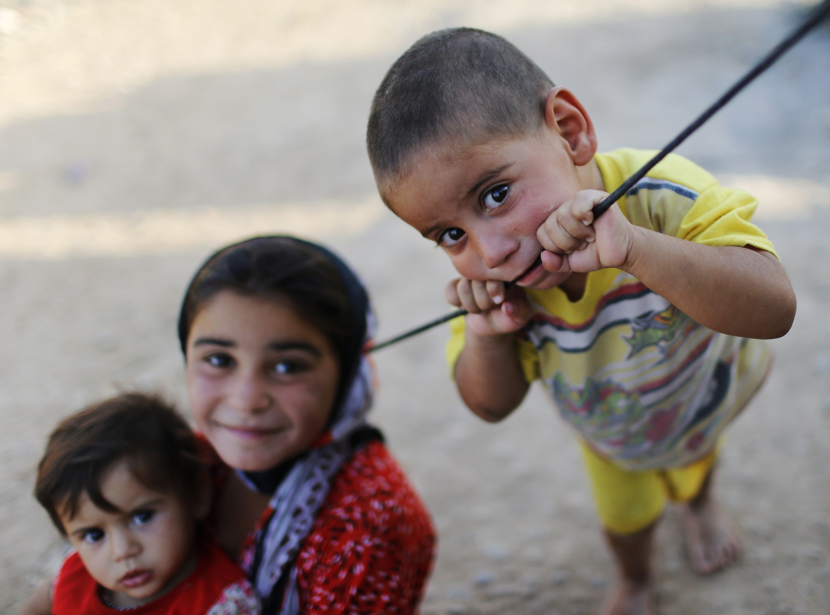 Displaced Iraqi children, who fled from Islamic Sate violence in Mosul, play outside their tent at Baherka refugee camp in Erbil September 14, 2014. REUTERS/Ahmed Jadallah (IRAQ - Tags: CIVIL UNREST CONFLICT SOCIETY)